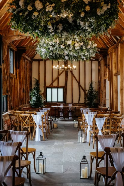 Barn dressed for a wedding with candles and plants at High House