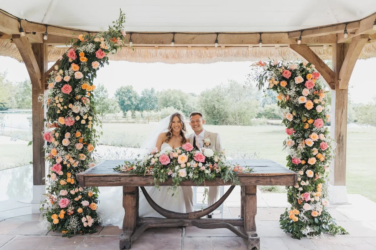 Couple sitting and smiling after getting married under Gazebo at High House