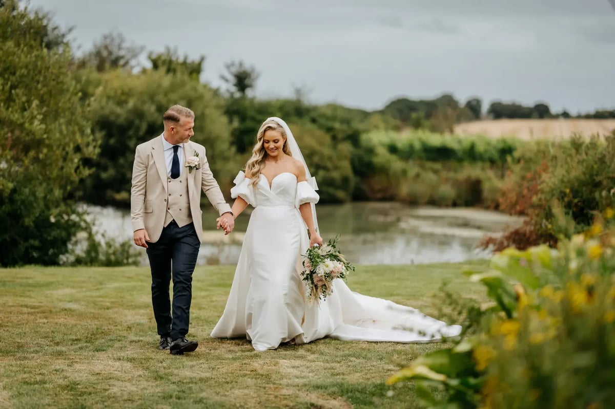 Bride and groom walking through the secret garden at High House