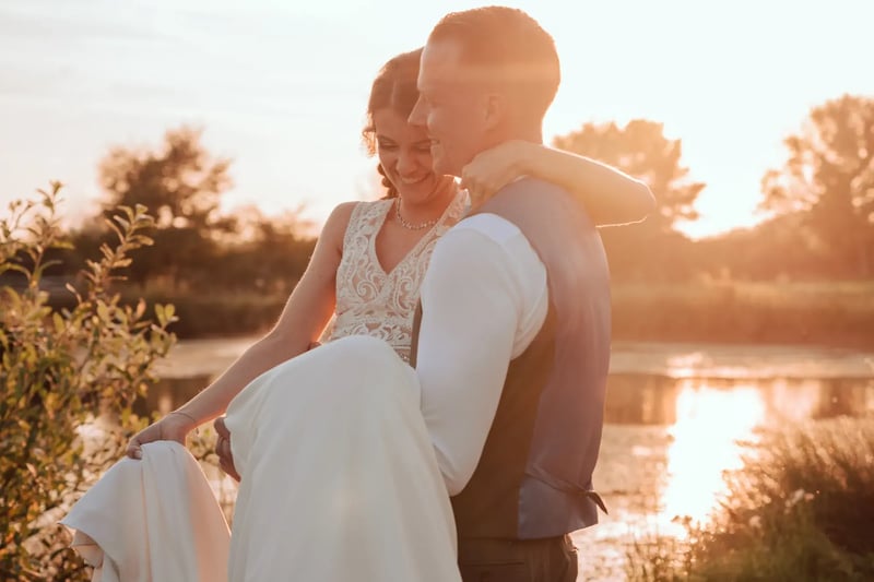 Couple smiling by the lake during golden hour at High House