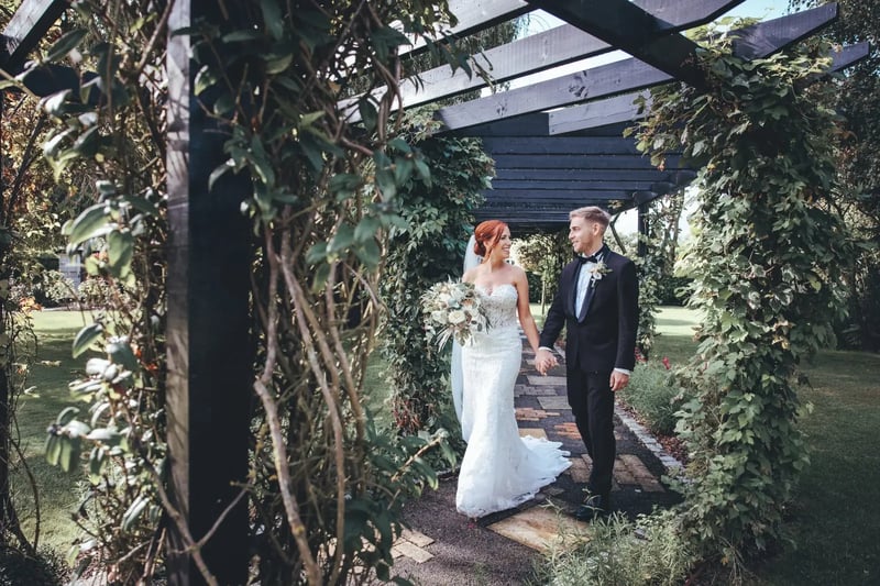 Coupe walking from outdoor wedding ceremony space at High House