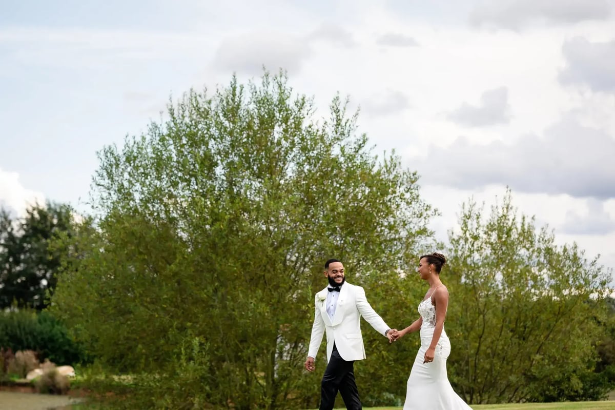 Couple smiling walking through grounds at High House