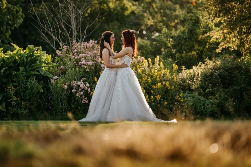 Brides holding eachother in the secret garden at High House