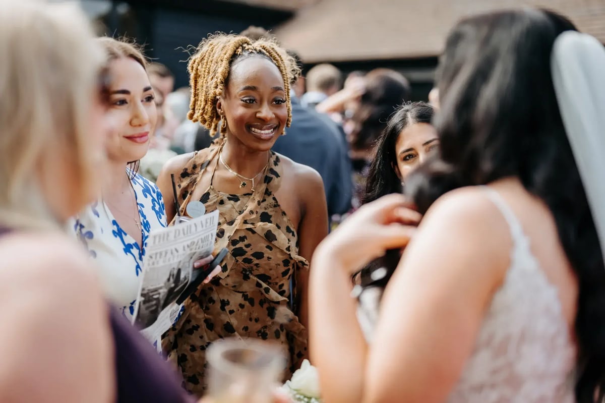 Guests laughing and talking to bride at High House