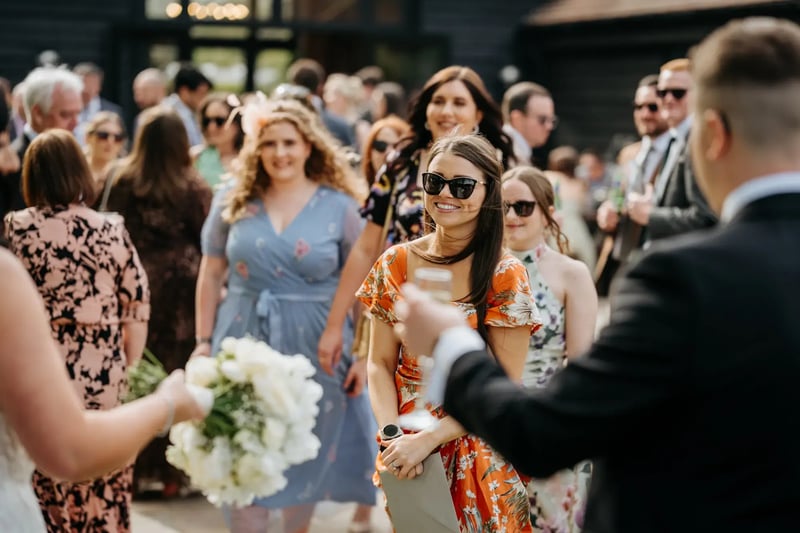 Wedding guests talking and smiling outside at High House