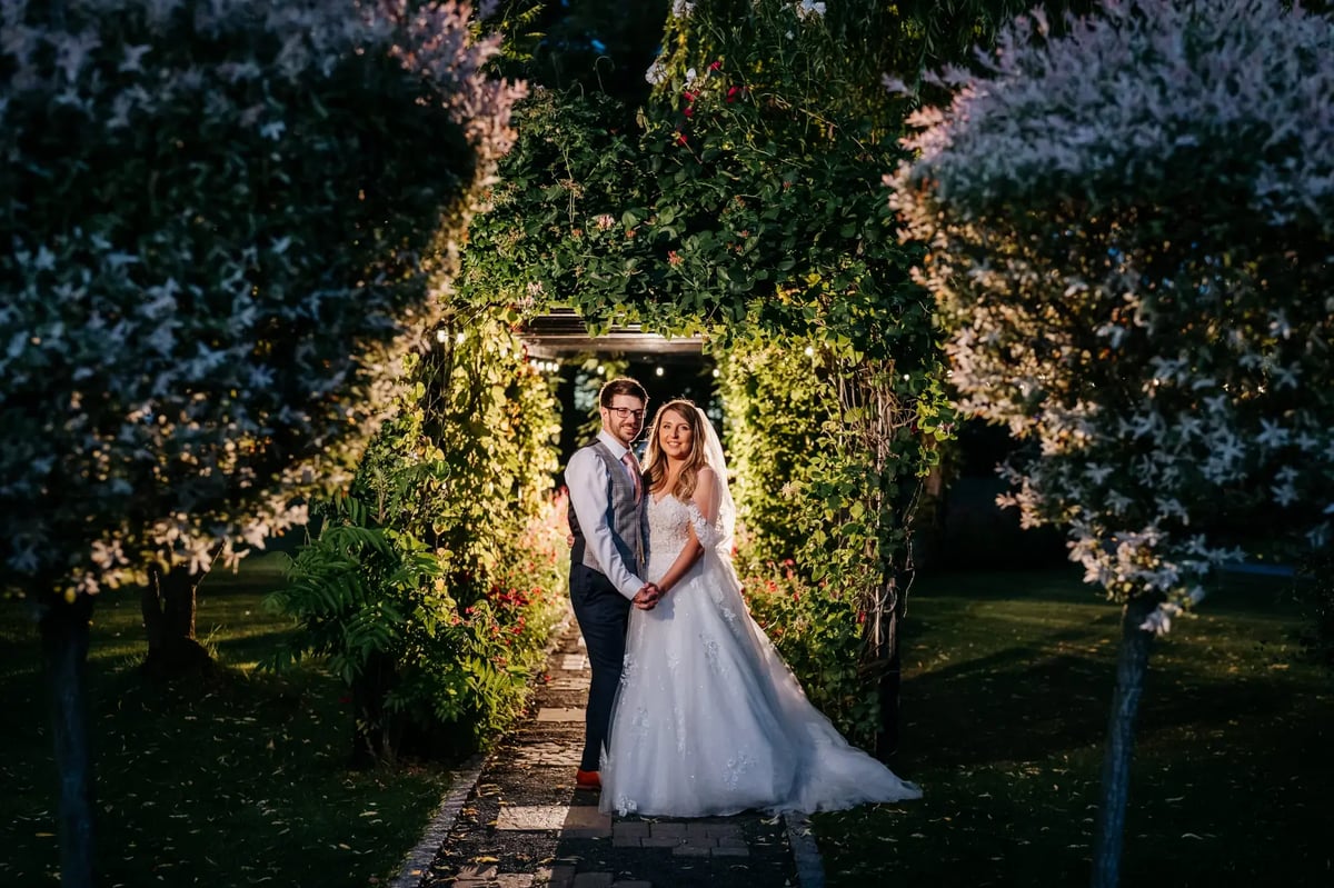 Bride and groom smiling and holding hands during the night outside at High High