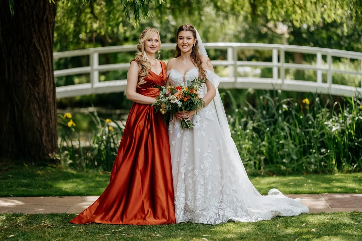 Bride and wedding party guest posing with bouquet at High House