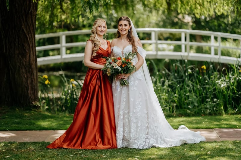 Bride and wedding party guest posing with bouquet at High House