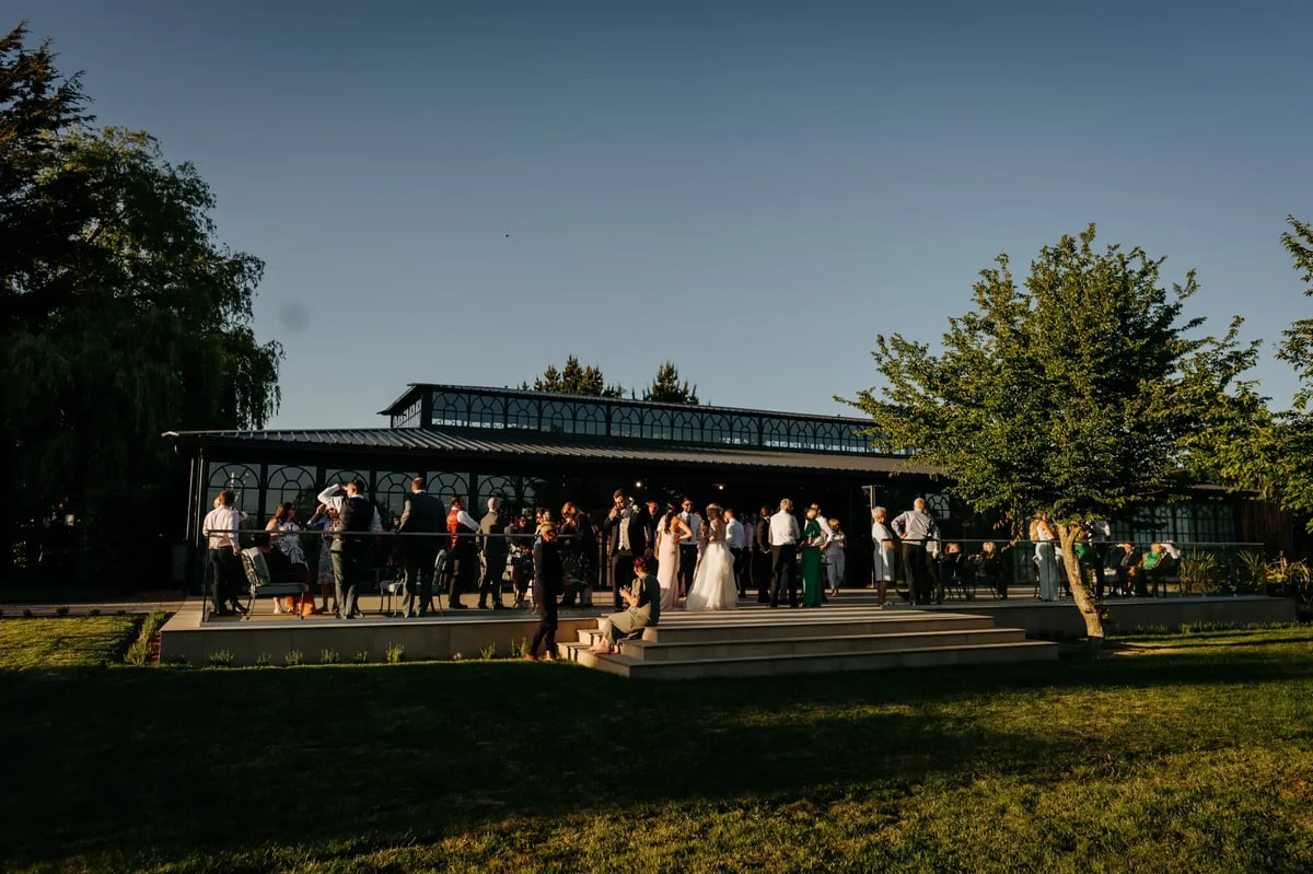 Wedding guests talking outside of the Orangery at High House