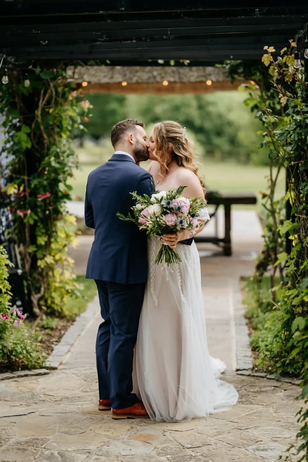Couple kissing under Gazebo outside at High House