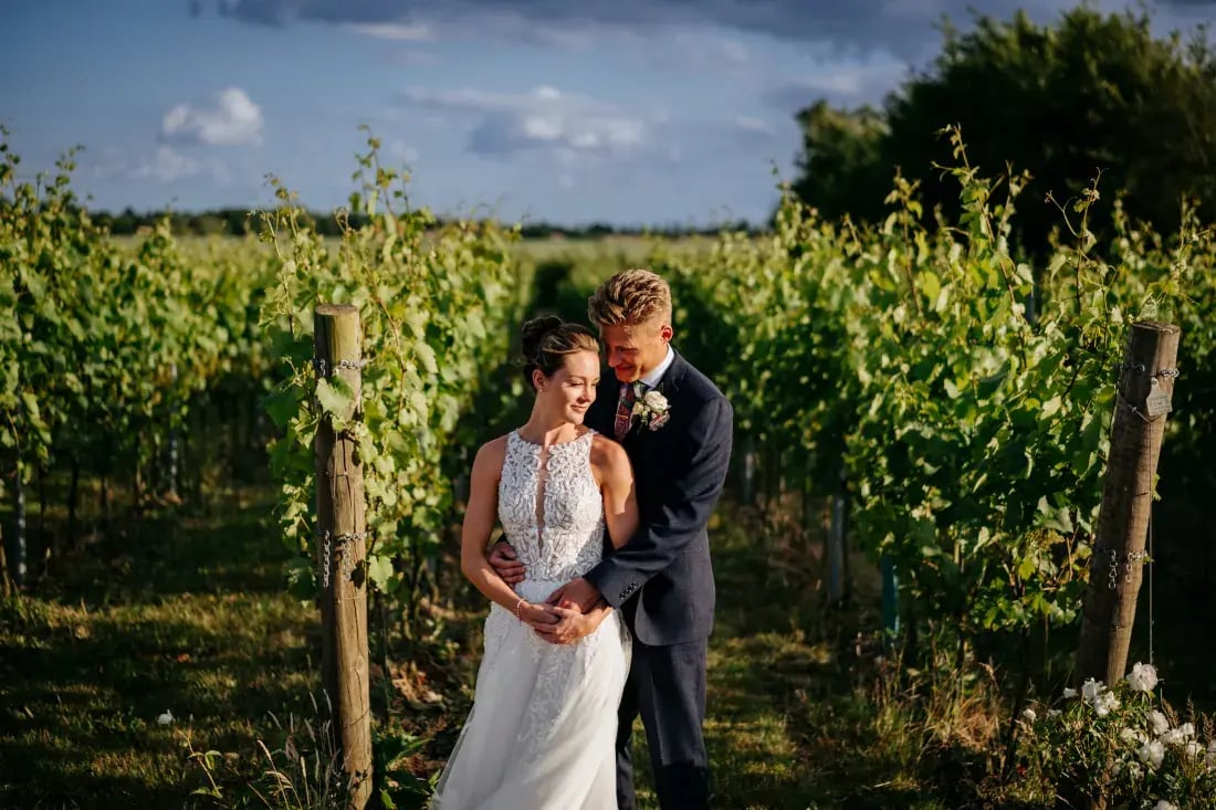 couple posing with backdrop of high house vineyard